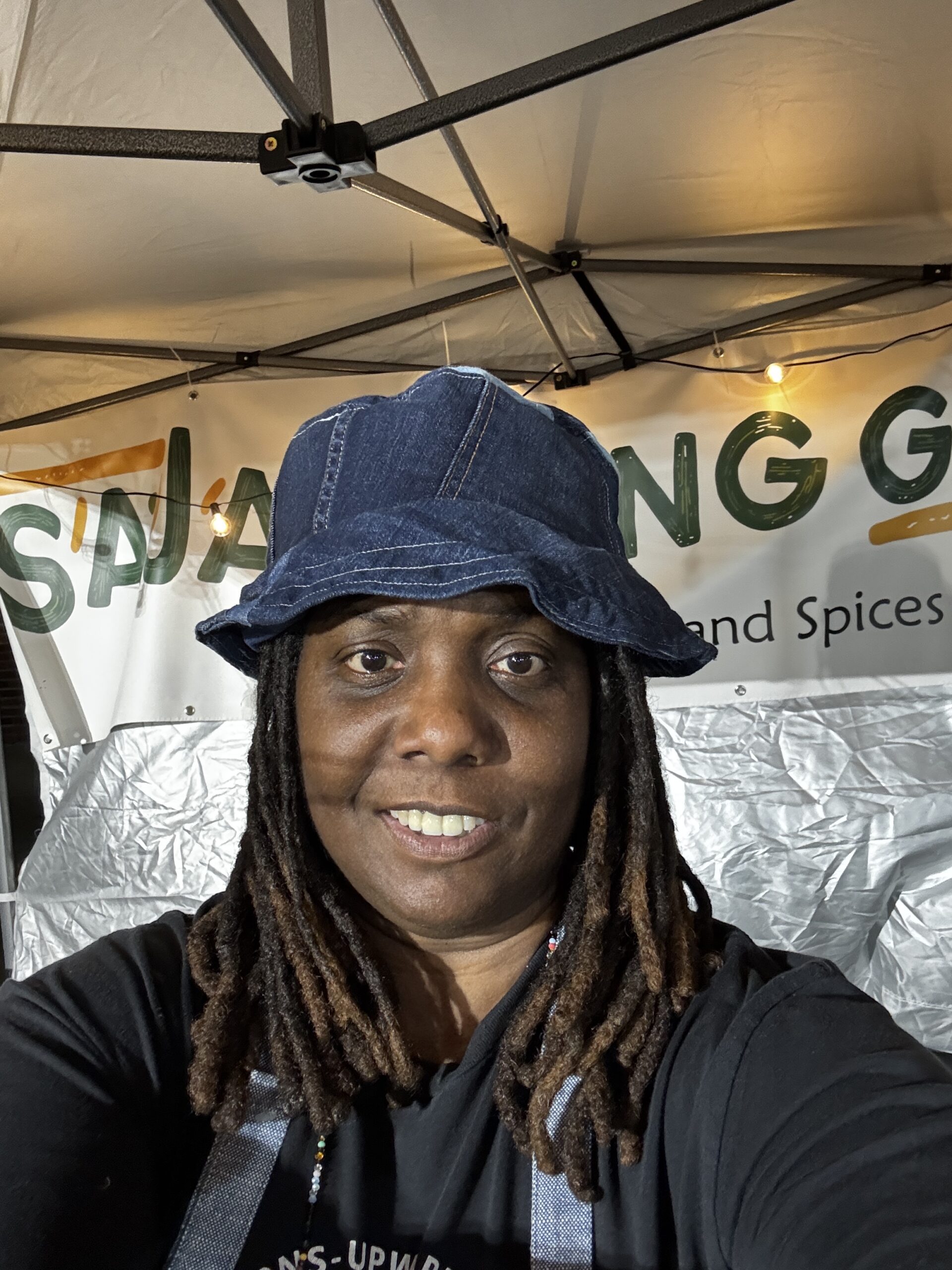 Picture of Black woman in a blue bucket hat, the owner of Saja Living Garden